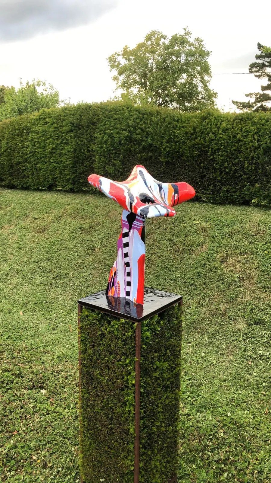 Sculpture contemporaine exposée sur la haie de la galerie verte